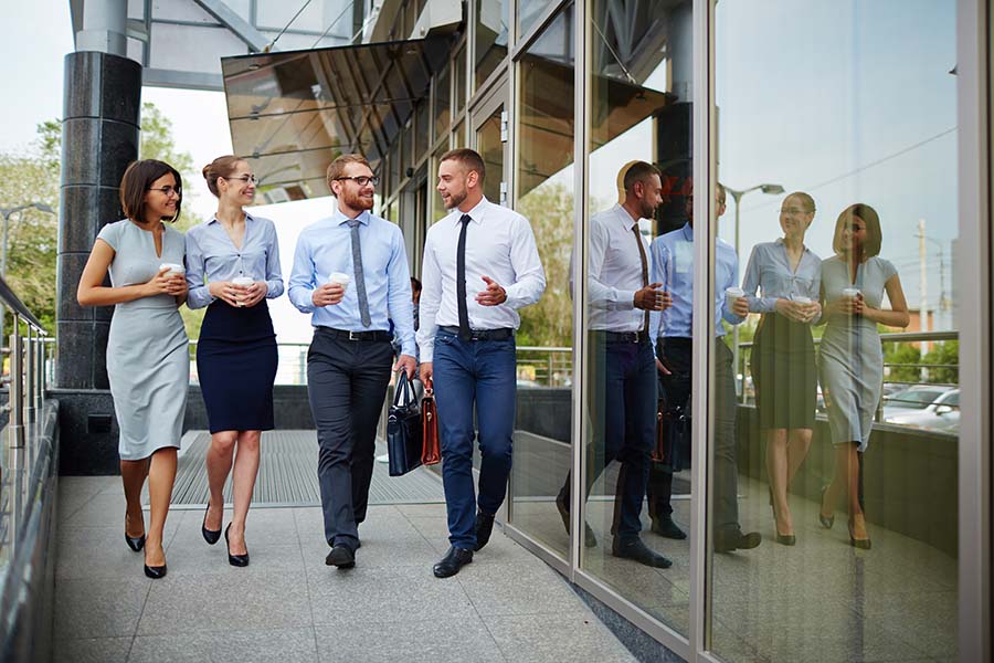 Employee Benefits - Portrait of a Cheerful Group of Business Colleagues Walking Outside a Corporate Building for Lunch